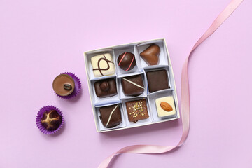 Box with delicious candies on purple background