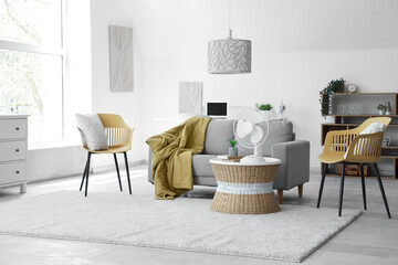 Interior of stylish living room with modern electric fan on coffee table