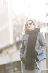 Beautiful girl in a ccoat and scarf and black glasses