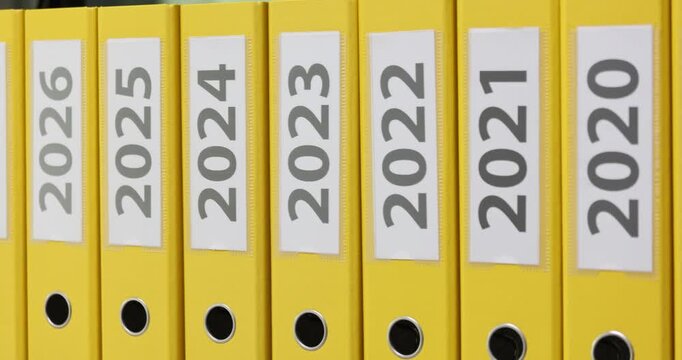 Yellow folders with document labels printed on years from 2022 to 2030