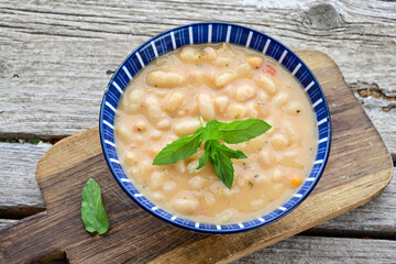   Homemade bean soup .Steamed white beans in tomato sauce  on a wooden background  