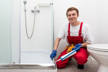 Plumber using silicone cartridge for fixing aluminum batten of shower cabin