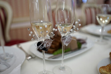 Wedding glasses are stylishly decorated and filled with champagne.