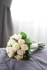 A beautiful bouquet of white roses in the room on the sofa.