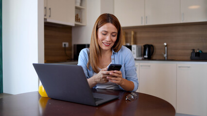 Woman tecting on smartphone while working from home