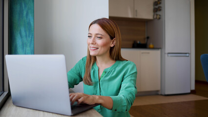 Beautiful woman using laptop and surfing the net at home