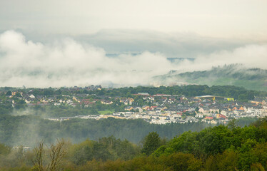 Dark storm clouds over the city of Trier in Germany, landscape with vineyards, agriculture field and forest, rainy weather in summer