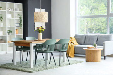 Interior of dining room with table, shelf unit and sofa