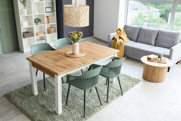 Interior of dining room with table, shelf unit and sofa