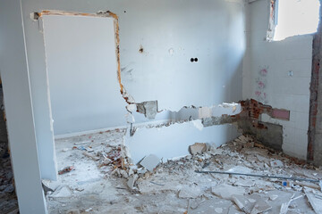 Ruined house with some parts of the walls collapsedwindows were removed for demolition. The cables...