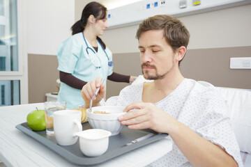 male patient eating meal in hospital bed