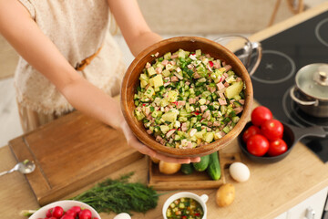 Young woman with tasty okroshka in kitchen, closeup
