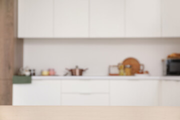 Blurred view of light kitchen with white counters and utensils