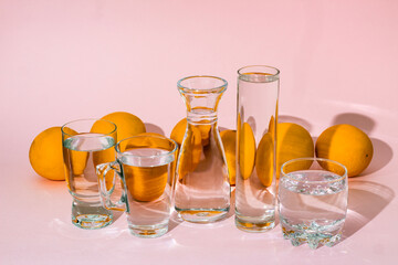 Oranges behind glass vessels filled with water. Distorted reflection.
