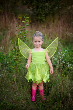 Beautiful toddler in green  fairy costume and pink boots