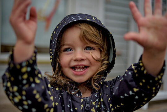 Beautiful toddler in raincoat blue eyes blonde curls