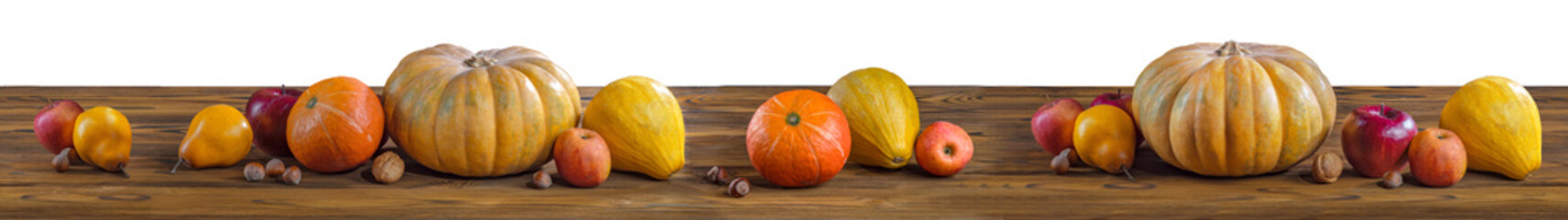 Thanksgiving day pumpkin harvest on a white isolated background. Squash, orange vegetable autumn fruit, apples, and nuts on a wooden table for traditional Halloween decoration fall design