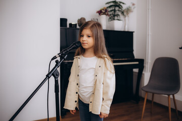 A little girl learns to sing at vocal lessons