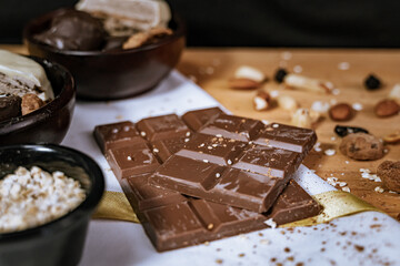 Chocolate chip cookies, dark and white chocolate bar, small bowl of oatmeal and nuts. International Chocolate Day.
