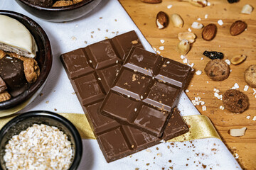 Chocolate chip cookies, dark and white chocolate bar, small bowl of oatmeal and nuts. International Chocolate Day.