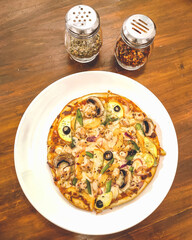 Pizza with oregano and chilly flakes top view at a cafe in Bhubaneswar, Odisha, India in February 2023....