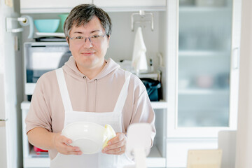 皿を拭く中年男性