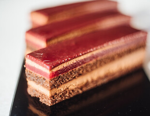 Three chocolate cakes on a black background. Mousse cake. Opera cake at the a La carte desserts , cakes on a black background. Selective focus