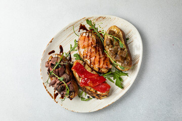 different types of bruschetta. With salmon, meat, soft cheese, herbs