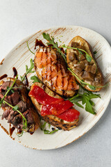 different types of bruschetta. With salmon, meat, soft cheese, herbs