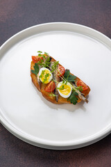 Delicious bruschetta with fish, cheese and herbs