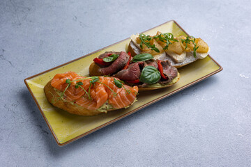 different types of bruschetta. With salmon, meat, soft cheese, herbs