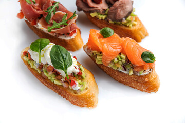 different types of bruschetta. With salmon, meat, soft cheese, herbs