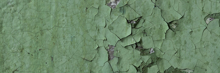 Peeling paint on the wall. Panorama of a concrete wall with old cracked flaking paint. Weathered...