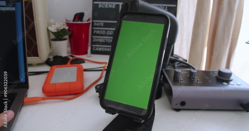 Poster beautiful close-up and slow motion shot of a mobile phone with green screen for animation resting on