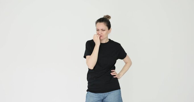 Woman nervously chews on finger walking back and forth. Lady body language reflects stress and preoccupation betraying inner turmoil