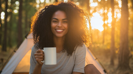 Young Black Woman with Curly Hair Holding Mug of Coffee or Tea - Relaxing in Front of Camping Tent in Forest, Enjoying Morning Drink in Nature Photo
