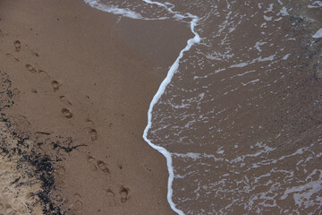 Human footprints in the sand on the seashore