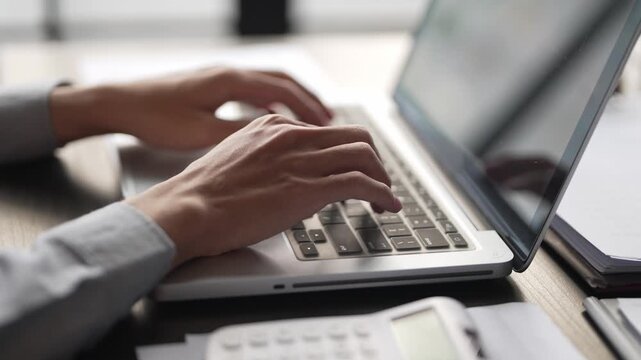 Close up hand typing on laptop surfing an internet