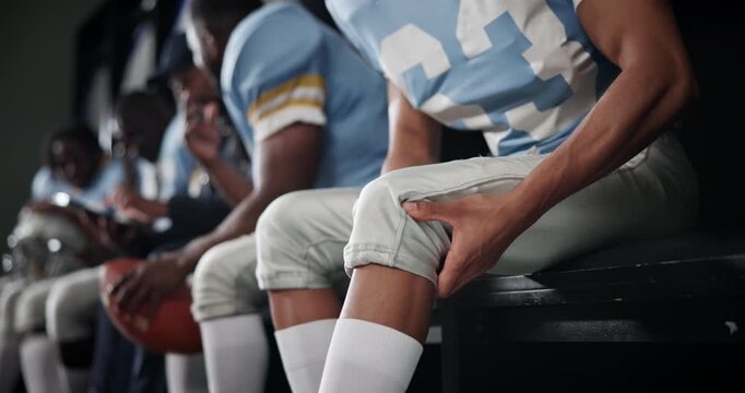 Knee injury, joint pain and hands with player in locker room, muscle tension and football with sports. Closeup, people or guy with health risk, game or hurt with training, holding leg and athlete