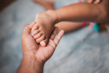 Baby's feet in mother's hands Newborn baby's toes cover a soft white background. Mother lovingly holds little feet and child care