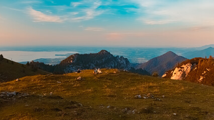Alpine summer evening view with hikers and Lake Chiemsee at Mount Kampenwand, Aschau, Chiemgau, Rosenheim, Bavaria, Germany