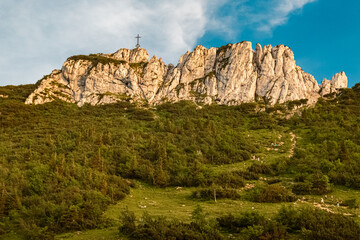 Alpine summer evening view with a summit cross at Mount Kampenwand, Aschau, Chiemgau, Rosenheim, Bavaria, Germany
