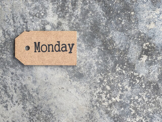 Day, time and calendar concept. Monday written on wooden tag. On blurred styled background.