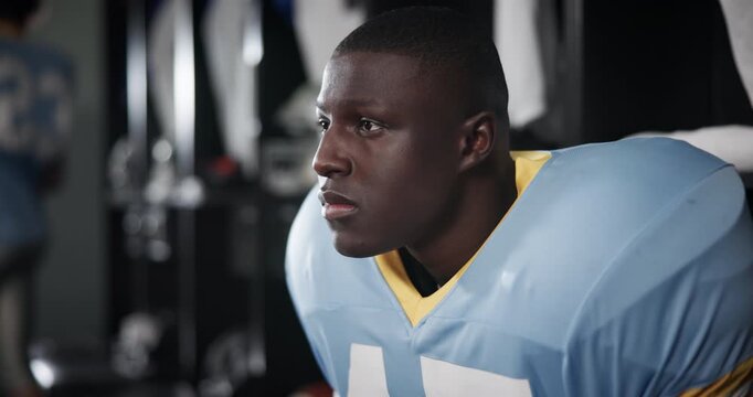 Black man, thinking and determination with football in locker room for match, break or half time. Serious African, athlete or male person in wonder for game plan, sports tournament or competition