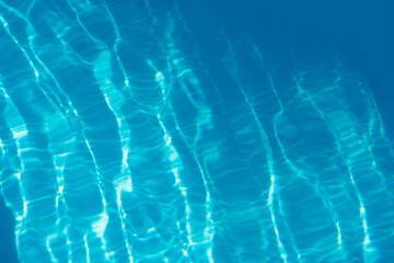 Swimming pool with turquoise blue clear water. Reflections of sky on a sunny day. Waves,...