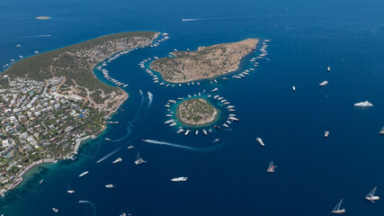 island surrounded by mega yachts