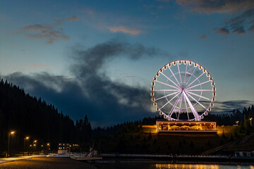 Night landscape, Ferris wheel with beautiful illumination at night. Attraction in Bukovel.