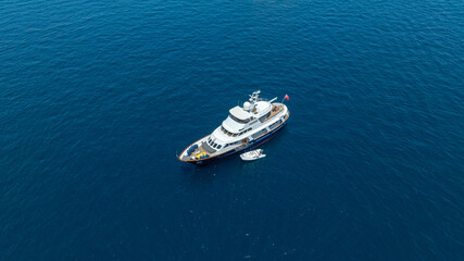 Fototapeta premium A breathtaking aerial view of a luxurious yacht cruising on the blue waters
