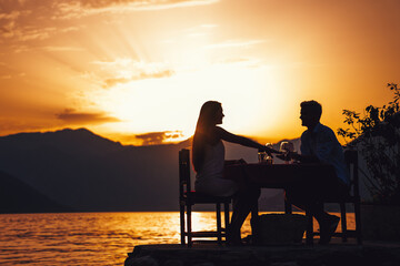 Couple is having a private event dinner on a tropical beach during sunset time