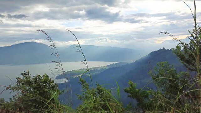 video of swaying grass above Lake Singkarak from the peak of Aua Sarumpun, West Sumatra